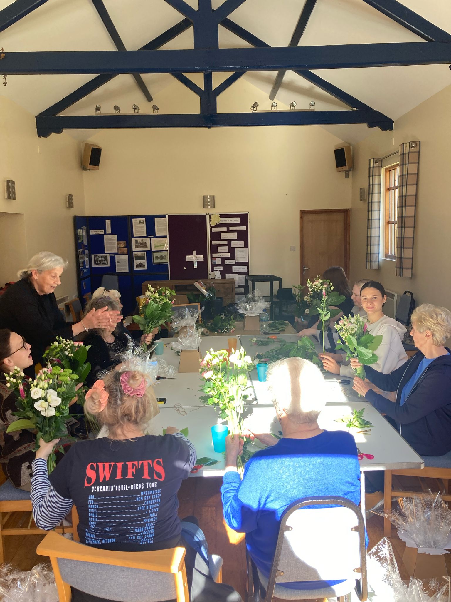 Church members arranging flowers together in the hall