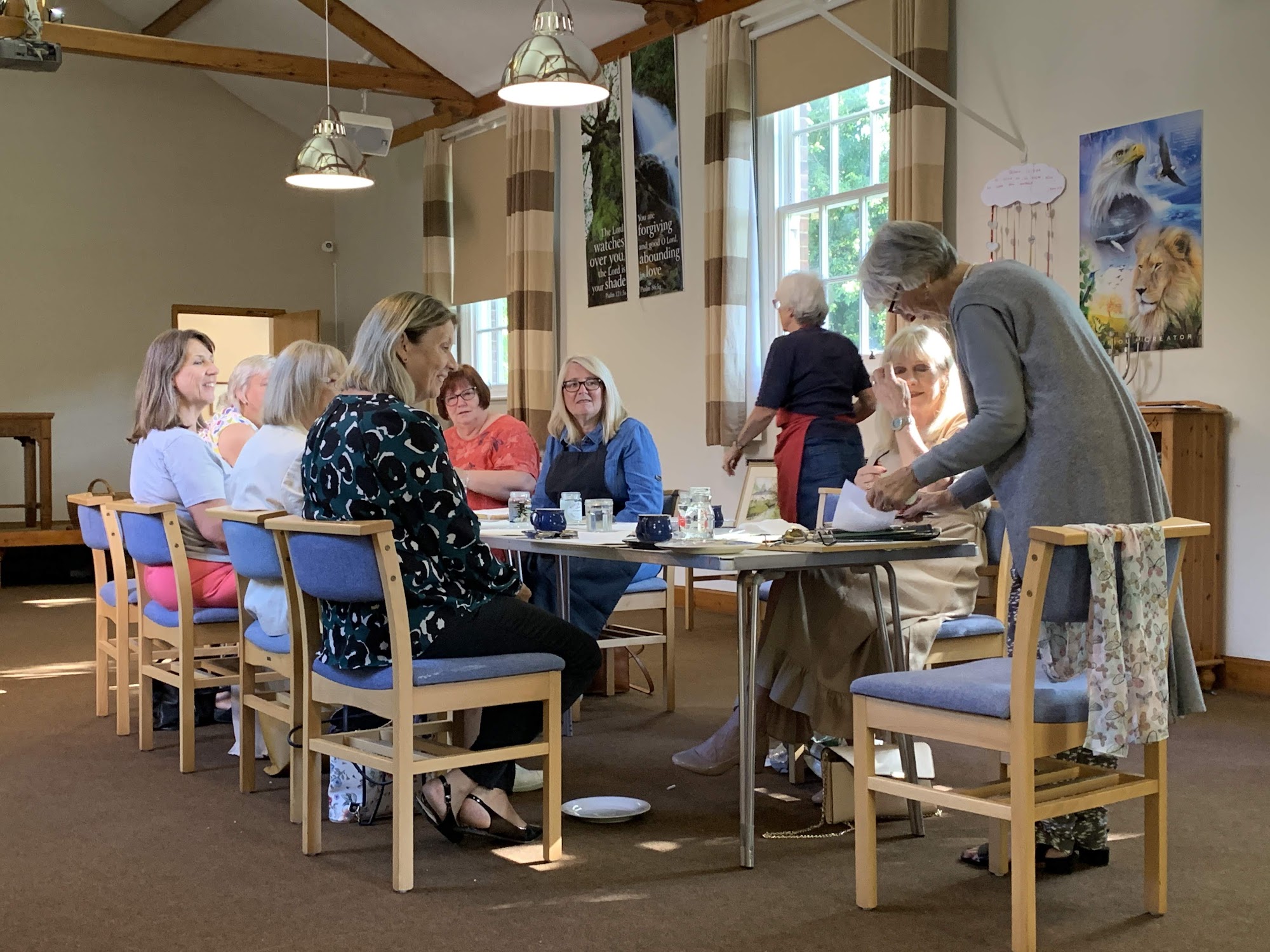 Church members chatting around a table in the hall